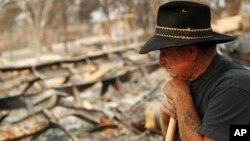Ed Bledsoe rests as he searches through what remains of his home, Aug. 13, 2018, in Redding, California. Bledsoe's wife, Melody, great-grandson James Roberts and great-granddaughter Emily Roberts were killed at the home in the Carr Fire. 