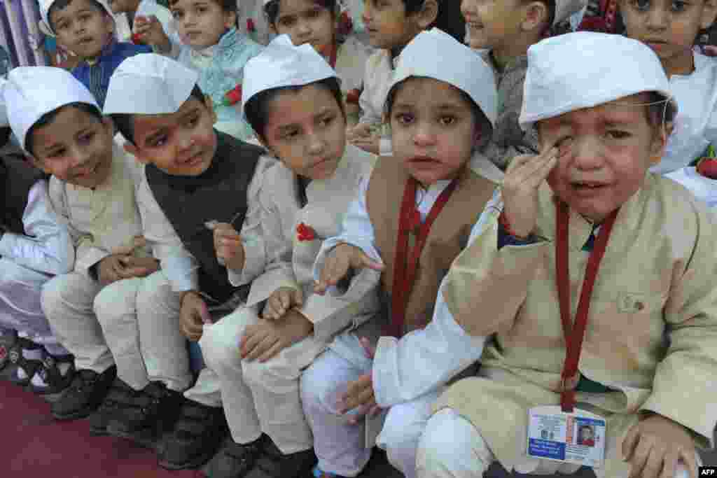 An Indian schoolboy (R) cries and he and schoolmates, dressed up as India's first prime minister Jawaharlal Nehru, pose during a photo event for Children's Day celebrations at a school in Amritsar, India's northwestern state of Punjab.