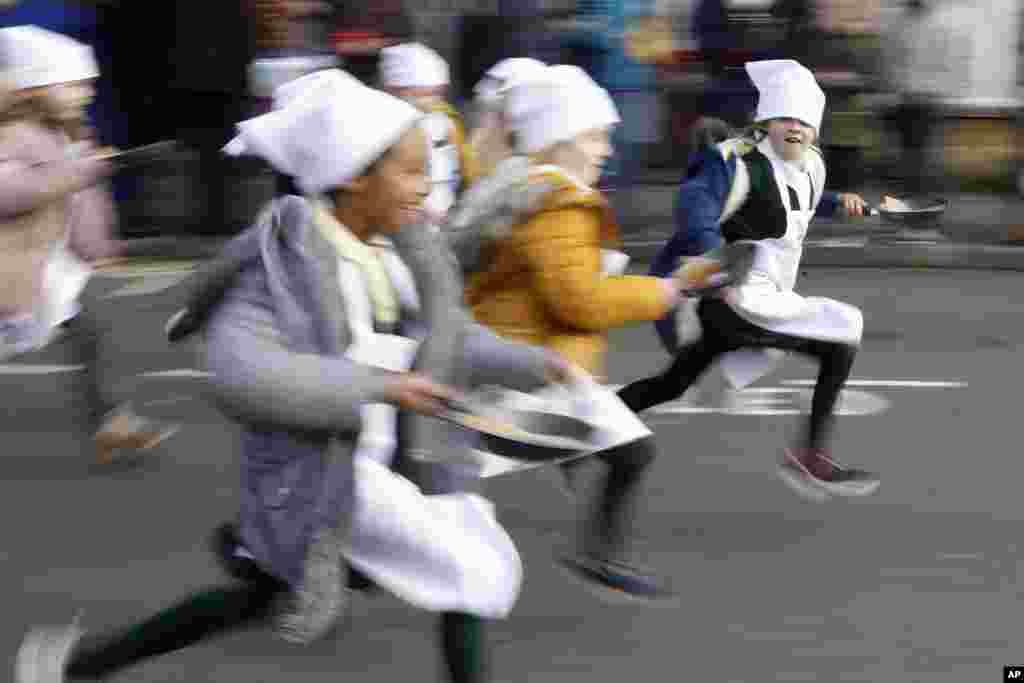 Schoolchildren from local schools take part in the children&#39;s races prior to the yearly Pancake race in Olney, Buckinghamshire, England, United Kingdom.