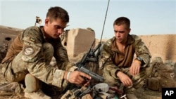 In this undated handout photo from Britain's Ministry of Defense made available on July, 31, 2010, Lt. Olly Field, left and Bombadier Matthew Nichols check their kit, after moving into a compound outside Sayedebad, central Helmand, Afghanistan.