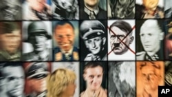 In this zoomed picture a visitor walks in front of the work 'Real Nazi' by Polish artist Piotr Uklanski during the press preview of the documenta 14, the world's most significant exhibition of contemporary art, in Kassel, Germany, June 8, 2017.