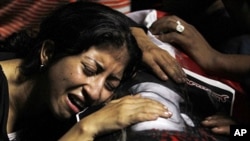 An Egyptian Christian woman mourns on the coffin of Coptic Christian Mina Demian, who was killed during clashes with soldiers and riot police late Sunday, at the morgue of the Coptic Hospital in Cairo October 10, 2011.