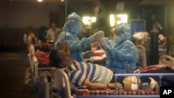 ကိုဗစ်ကူးစက်ခံရသူ တဦးအား ဆေးကုသပေးနေသည့် ကျန်းမာရေးဝန်ထမ်းများကို အိန္ဒိယနိုင်ငံ New Delhi မြို့က ဆေးရုံတခုမှာ တွေ့ရ။ ။ (ဧပြီ ၃၀၊ ၂၀၂၁)
