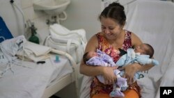 Severina Raimunda porte dans ses bars sa petite-fille Melisa Vitoria, à gauche, qui est né avec une microcéphalie et son frère jumeau Edison junior à l'hôpital de IMIP à Recife, dans l'Etat de Pernambuco, au Brésil, 3 février 2016. 