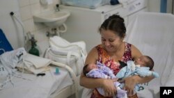 Severina Raimunda porte dans ses bars sa petite-fille Melisa Vitoria, à gauche, qui est né avec une microcéphalie et son frère jumeau Edison junior à l'hôpital de IMIP à Recife, dans l'Etat de Pernambuco, au Brésil, 3 février 2016. 