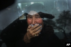 FILE - A Hazara tribeswoman cries in a car as thousands march through the Afghan capital of Kabul on Nov. 11, 2015, carrying the coffins of seven ethnic Hazaras who were allegedly killed by the Taliban.