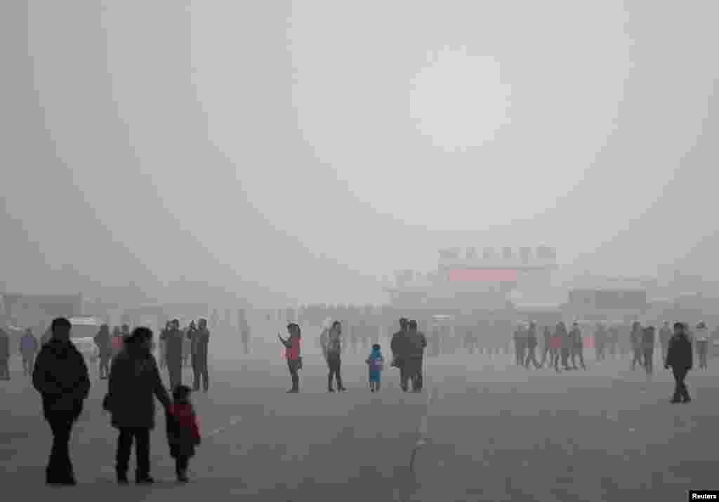 People visit the Olympic Park amid thick haze in Beijing, Feb. 25, 2014.&nbsp;