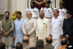 India Prime Minister Narendra Modi, third left, President Ramnath Kovind, third right and Vice President Venkiah Naidu, second right, pose with the newly sworn-in ministers Mukhtar Abbas Naqvi, left, Dharmendra Pradhan, second left and Piyush Goyal, right.