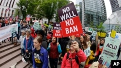 FILE - Protesters wave signs and chant during a demonstration against President Donald Trump's travel ban, outside a federal courthouse in Seattle, Washington, May 15, 2017. 