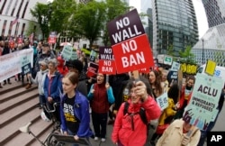 FILE - Protesters wave signs and chant during a demonstration against President Donald Trump's travel ban, outside a federal courthouse in Seattle, Washington, May 15, 2017.