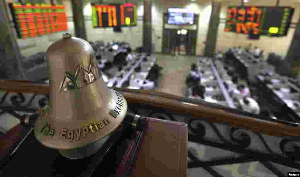 Traders are seen working below the Egyptian Exchange bell at the stock exchange in Cairo. Selling pressure from foreign investors dragged Egypt&#39;s bourse down to a near 16-week low on Sunday as the country&#39;s economic situation worsens. 