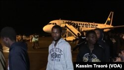 152 Maliens rapatriés de la Libye au pied de l'avion, à l'aéroport Modibo Keita de Bamako Senou, Bamako, Mali, 7 décembre 2017. (VOA/Kassim Traoré)