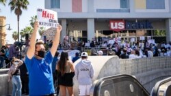 An Asian-American man raises a sign during a rally to speak up and show solidarity for the AAPI community at Thai Town, Los Angeles California, U.S., on April 8, 2021.