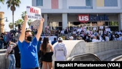 今年4月美國洛杉磯泰國城一場反仇恨亞太裔的集會上，一名亞裔美國人高舉標語。