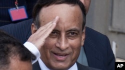 FILE - Pakistan's former ambassador to the U.S., Hussain Haqqani, salutes to media as he leaves after appearing before a judicial commission at a high court in Islamabad, Pakistan, Jan. 9, 2012. 