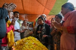 FILE - People mourn at the body of a local pandit businessman, gunned down the day before, at his home in Srinagar, Indian-administered Kashmir, Oct. 6, 2021.
