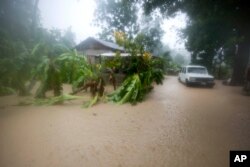 ລົດຄັນນຶ່ງຈອດຢູ່ໃກ້ເຮືອນ ທີ່ຖືກນ້ຳຖ້ວມ ຍ້ອນເຮີຣິເຄນ Matthew ທີ່ເມືອງ Leogane ປະເທດເຮຕີ