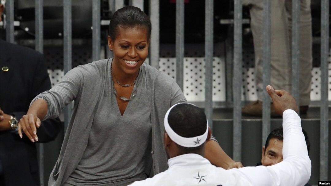 Ibu negara Michelle Obama memeluk pemain bola basket AS, LeBron James setelah memenangkan pertandingan melawan tim Perancis (29/7).
