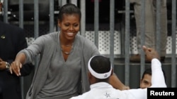 Ibu negara Michelle Obama memeluk pemain bola basket AS, LeBron James setelah memenangkan pertandingan melawan tim Perancis (29/7).