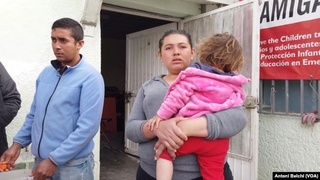 Una mujer lleva en brazos a su hija en el albergue "El Buen Samaritano" impulsado por el pastor Juan Fierro García en Ciudad Juárez, México.