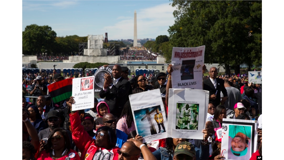 People cheer during a rally to mark the 20th anniversary of the Million Man March in Washington, Oct. 10, 2015.