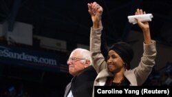 La représentante Ilhan Omar (à droite) tient la main du sénateur Bernie Sanders à l'Université du Minnesota - Minneapolis à Minneapolis, Minnesota, États-Unis le 3 novembre 2019. REUTERS/Caroline Yang