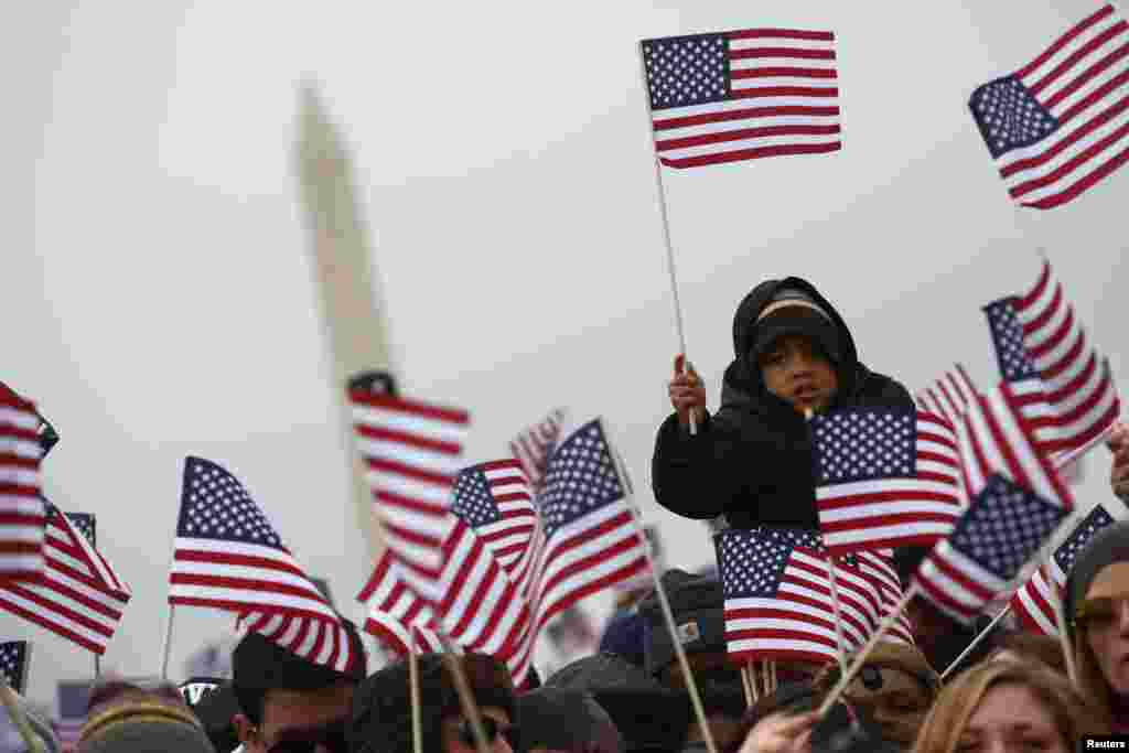 Spectators react on the National Mall during the 57th inauguration ceremonies for President Barack Obama and Vice President Joe Biden on the West front of the U.S. Capitol, in Washington, D.C.&nbsp;