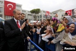 FILE - Turkey's President Tayyip Erdogan (L) greets students and parents during a ceremony to mark the start of the new school year at Ahmet Sani Gezici Girls' Imam Hatip School in Istanbul, Turkey.