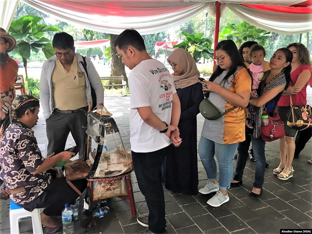 Warga antre jajanan gratis yang disediakan panitia usai mencoblos di TPS 40 Menteng, Jakarta, Rabu, 17 April 2019.(Foto: Ahadian Utama/VOA)