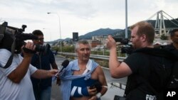 An injured man talks to reporters as he leave the site where the Morandi highway bridge collapsed in Genoa, northern Italy, Aug. 14, 2018. 