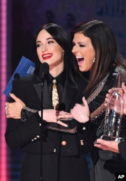 Karen Fairchild of Little Big Town, right, embraces Kacey Musgraves​, winner of the award for album of the year for "Golden Hour" at the 52nd annual CMA Awards at Bridgestone Arena, Nov. 14, 2018, in Nashville, Tenn.