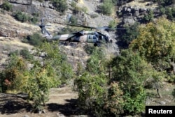 FILE - A Turkish military helicopter flies at low altitude along a mountain in Cukurca, near the Iraqi border in southeastern Turkey, where thousands of Turkish troops had launched a ground and air offensive against PKK fighters, Oct. 21, 2011.