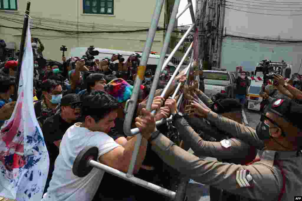 Anti-government protesters scuffle with police outside a police station in Bangkok.