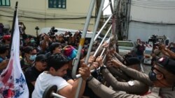 Anti-government protesters scuffle with police outside a police station in Bangkok.