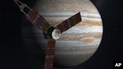 This NASA image shows an artist rendering of the Juno spacecraft circling Jupiter.