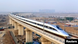 FILE - A high-speed train travelling to Guangzhou is seen running on Yongdinghe Bridge in Beijing, December 26, 2012. 