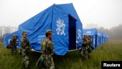 Paramilitary policemen set up a relief tent in Yongping township after an earthquake hit Jinggu county, Yunnan province, October 8, 2014. 
