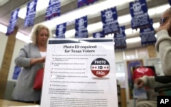 A sign tells voters of voter ID requirements before participating in the primary election at Sherrod Elementary school in Arlington, Texas, March 1, 2016.