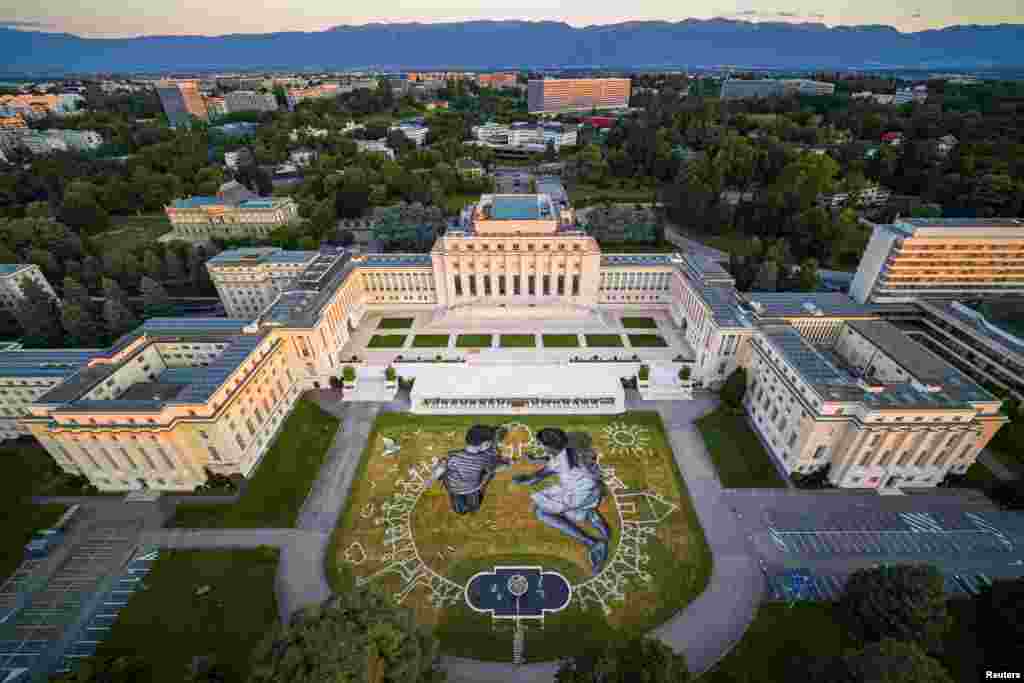 A view of artwork called &quot;World in progress&quot; by French artist Saype shows two children as they draw a tree to mark the 75th anniversary of the founding of the United Nations, on the grounds of its European headquarters, in Geneva, Switzerland.