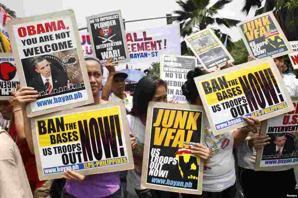 Para demonstran membawa poster-poster dalam protes menolak kunjungan Presiden AS Barack Obama di depan Kedutaan Besar Amerika di Manila, Filipina (23/4).&nbsp;(Reuters/Romeo Ranoco)