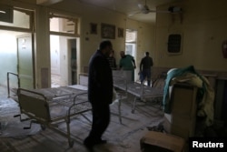People inspect damage in Omar Bin Abdulaziz hospital, in the rebel-held besieged area of Aleppo, Syria, Nov. 19, 2016.