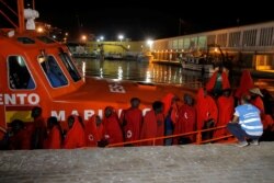 Seorang anggota Frontex berbicara dengan para migran yang diselamatkan di lepas pantai Laut Mediterania, saat mereka menunggu untuk turun dari kapal penyelamat di pelabuhan Malaga, Spanyol selatan, 2 September 2019.