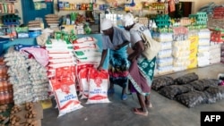 FILE: Two elderly women shop for mealie meal and other basic commodities, March 14 2019, in the Mutoko rural area of Zimbabwe. 