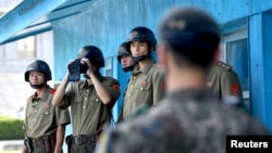 지난 13일 판문점 북한 군인이 망원경으로 남측 지역을 살피고 있다.