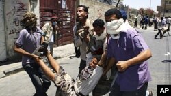 Anti-government protesters carry an injured fellow protester during clashes in the southern Yemeni city of Taiz, April 5, 2011