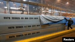 FILE - An employee removes a covering of 13-meter aluminium ingots at the foundry shop of the Rusal Krasnoyarsk aluminium smelter in Krasnoyarsk, Russia, July 27, 2016. Rusal has been sanctioned by the U.S. government.