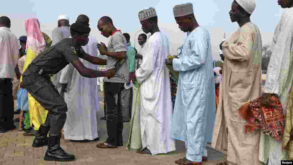 A policeman scans people before the start of prayers in Abuja.