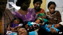 Women hold their newborn babies at a program in Chennai, India.