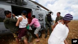 Cư dân bị mắc kẹt dỡ hàng cứu trợ từ một máy bay trực thăng của Hải quân Hoa Kỳ cho những người bị cô lập bởi siêu bão Haiyan, 16/11/2013