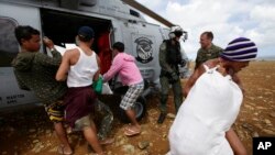 Warga membantu menurunkan bantuan darurat untuk para korban topan Haiyan yang terisolasi di pulau Manicani, sebelah Timur provinsi Samar, Filipina Tengah dari helikopter Tentara Angkatan Laut AS (16/11).